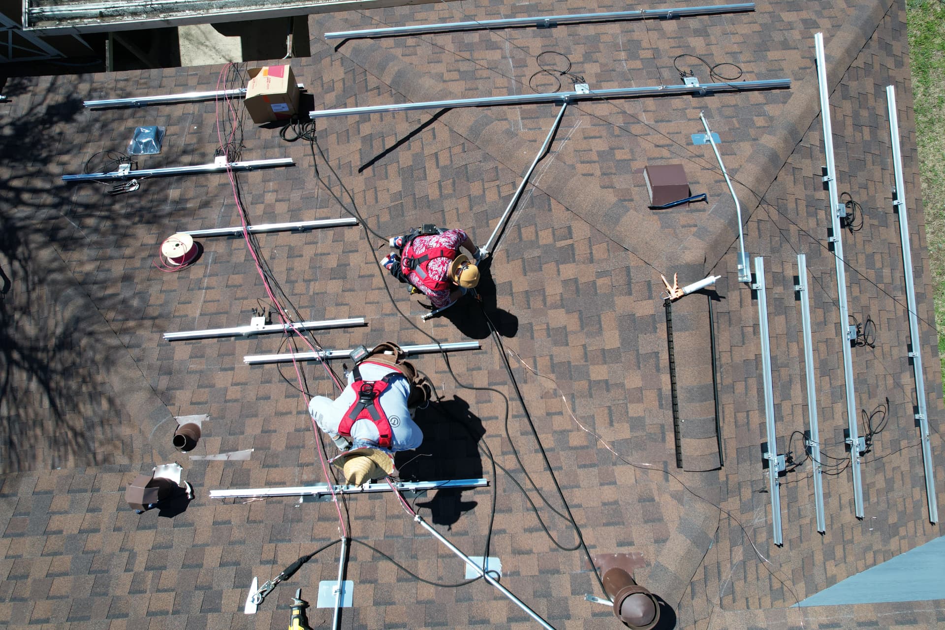 Installers mounting solar racking rails on a residential shingle roof
