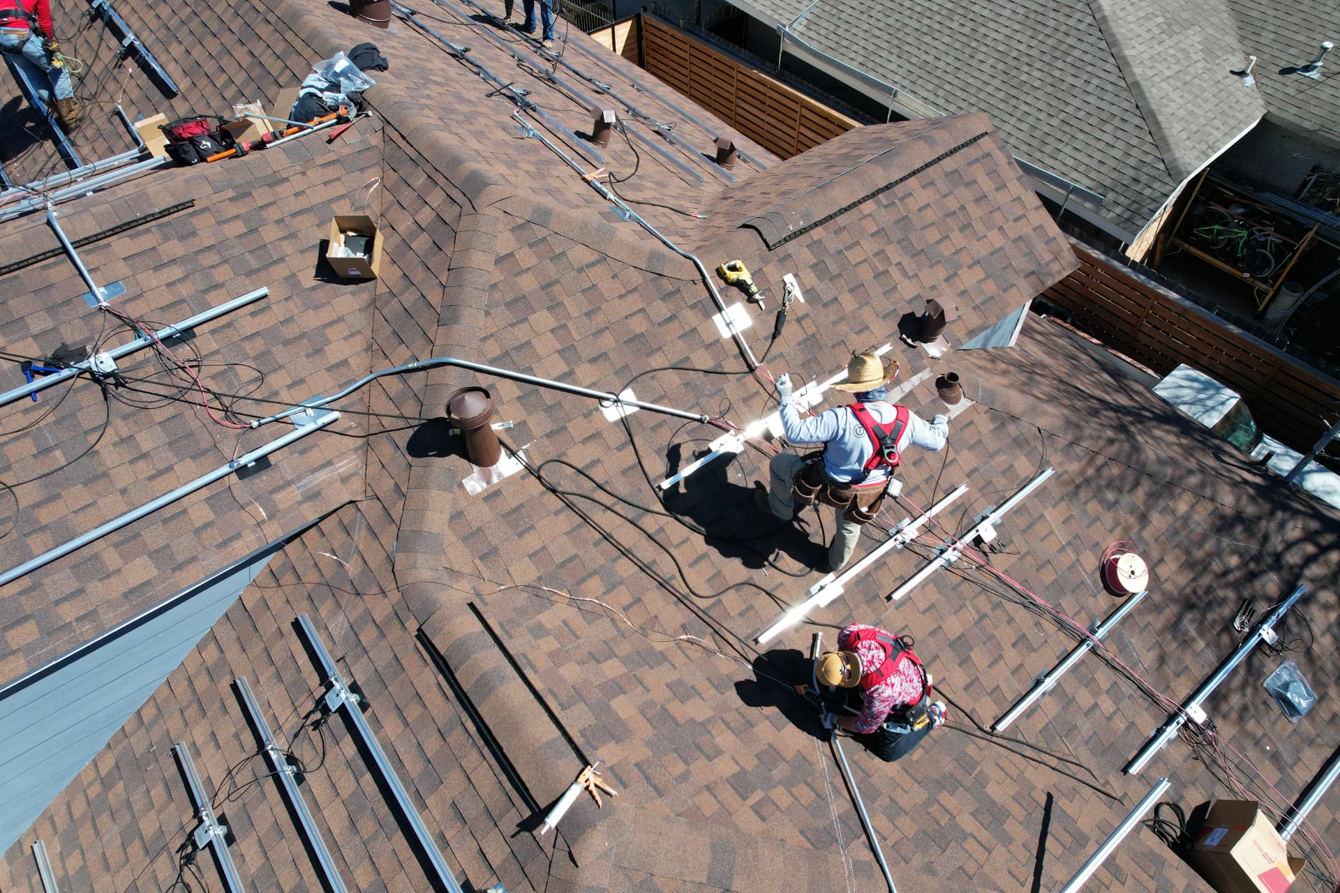 Aerial photo of solar mounting rails and wiring being set on a residential roof