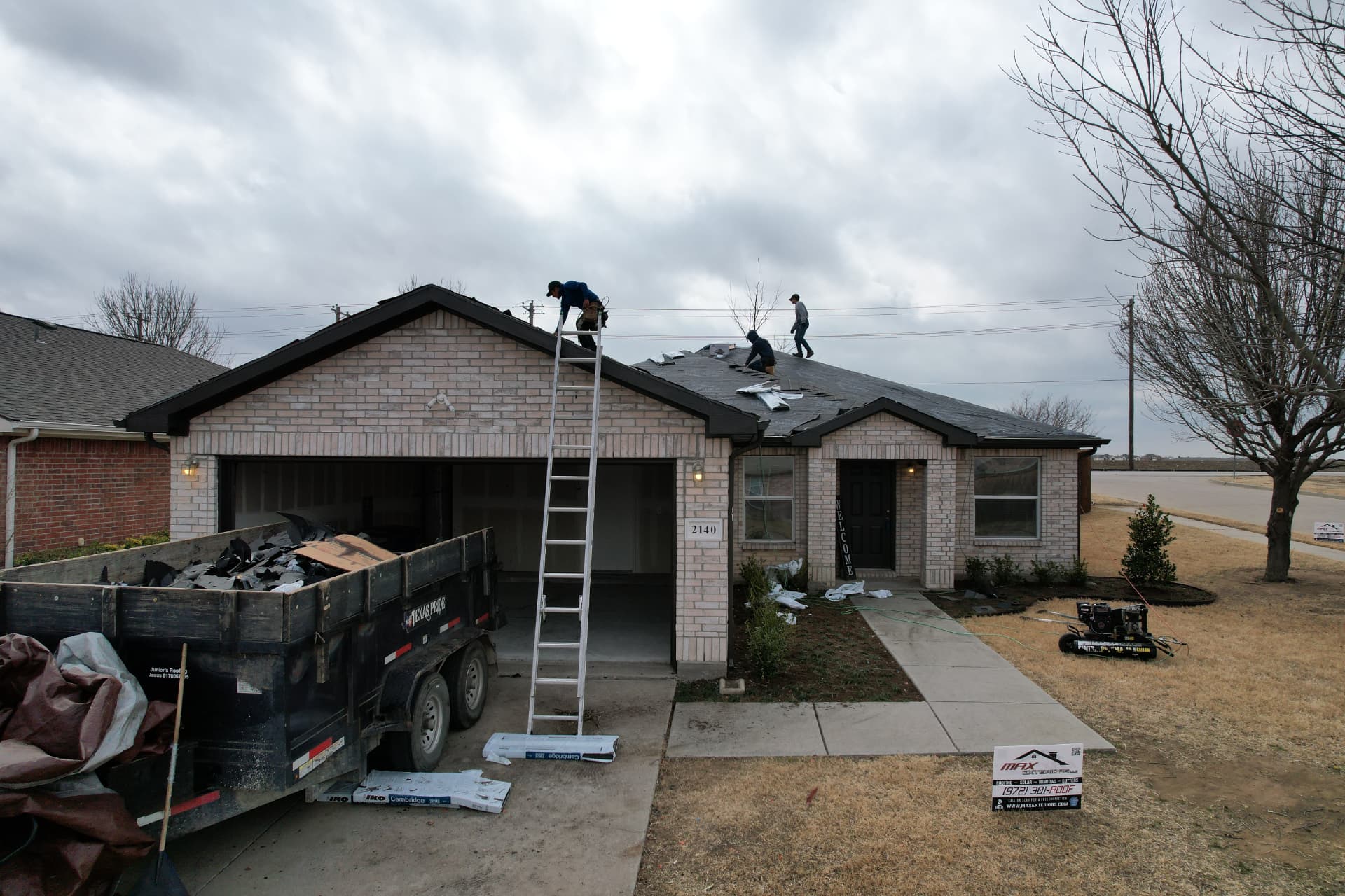 Max Exteriors crew and yard sign on an active roof replacement job site in North Texas